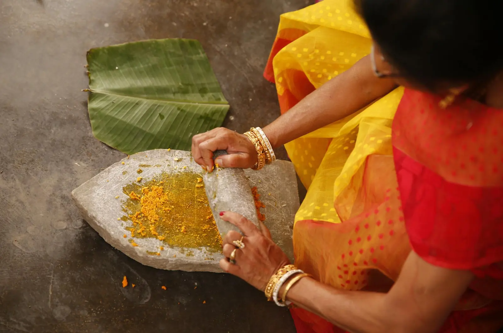 Traditional turmeric and herb grinding for Ayurveda, Kerala