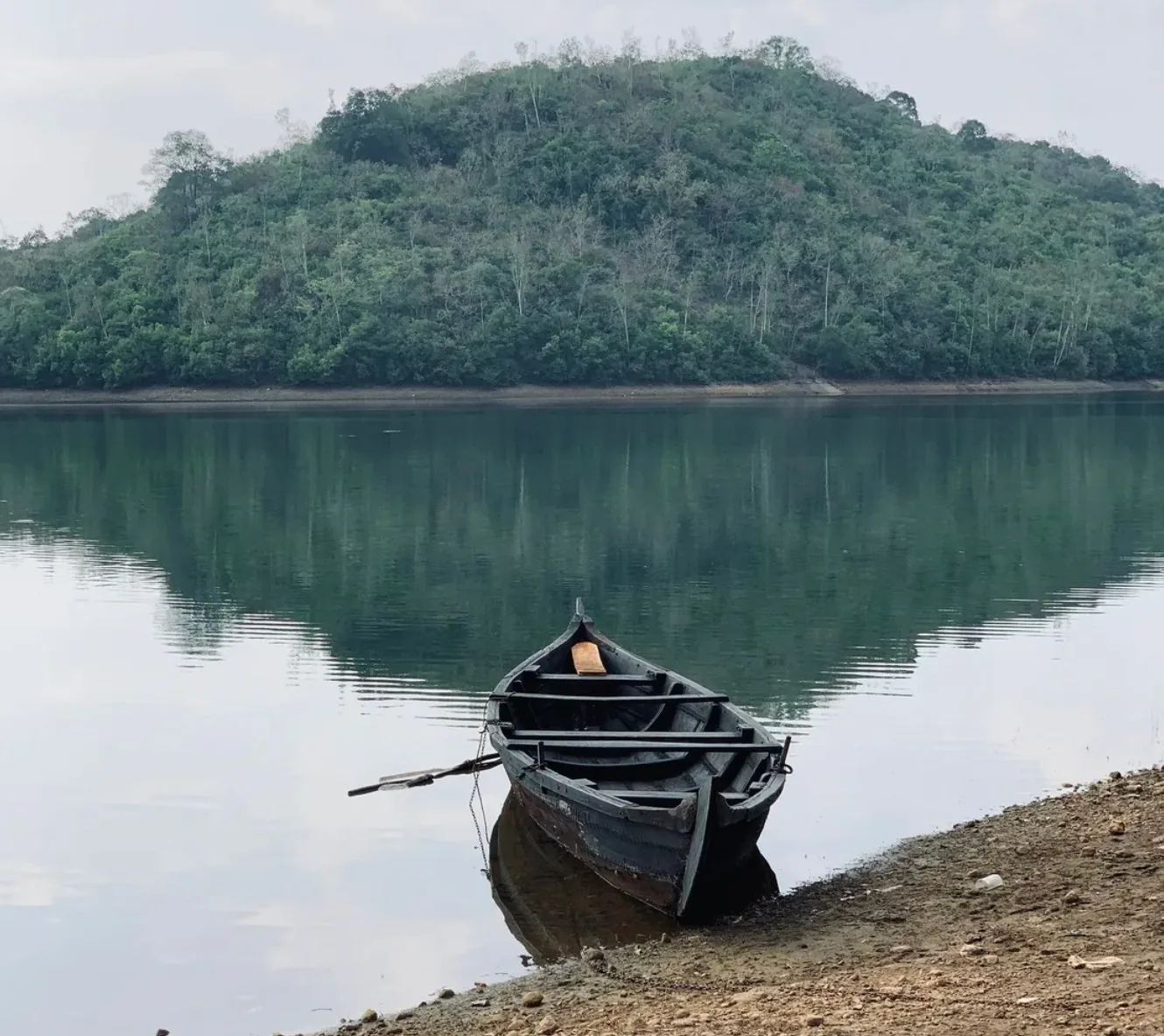 Wooden canoe on a reservoir near Thekkady — Kerala holiday package